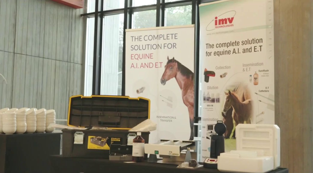 A sponsor stand at ESER displaying equine veterinary equipment with posters in the background.
