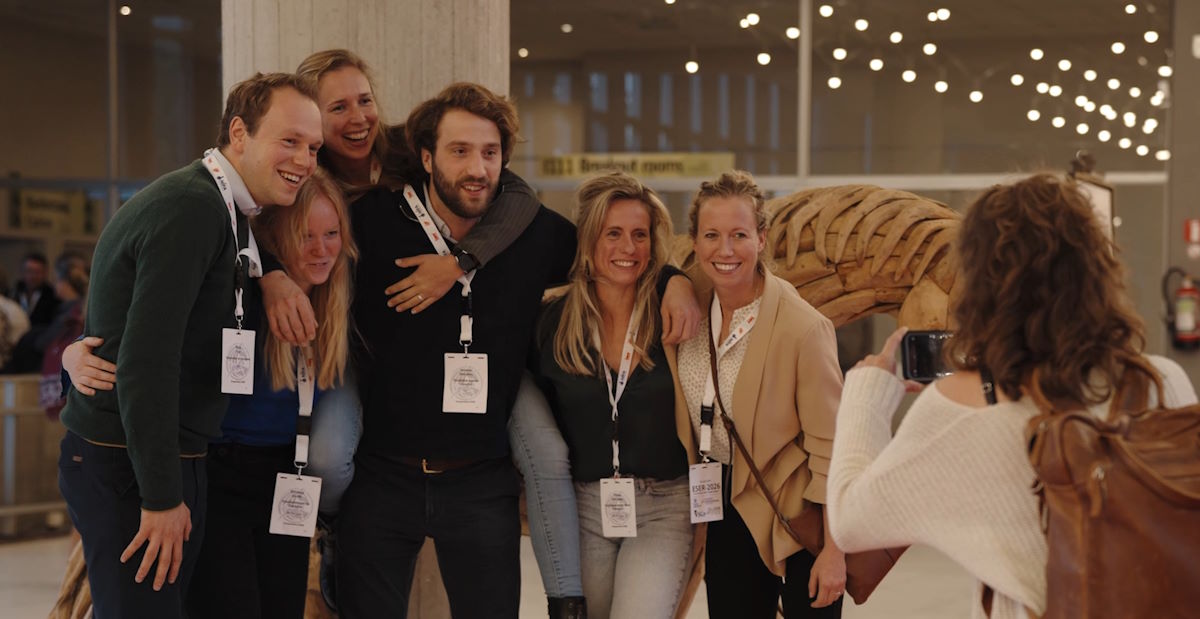 A group of attendees wearing lanyards posing together for a photo at ESER.