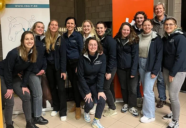A group of attendees wearing lanyards posing together for a photo at ESER.